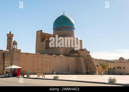 Westliche Mauer der Kalyan Moschee mit alten Mauern und großer farbenfroher Kuppel vor klarem blauem Himmel Stockfoto