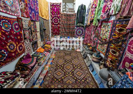 Vielfalt der herrlichen orientalischen Teppiche im traditionellen Teppichgeschäft im Nahen Osten. Ein Haufen wunderschöner handgemachter Teppiche im traditionellen Nahen Osten Stockfoto