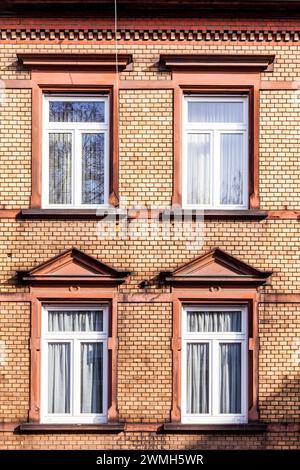 Fassade des klassizistischen Hauses mit Backsteinmauer und modernen Fenstern Stockfoto