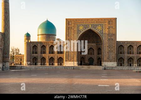 Traditionelle usbekische religiöse Architektur in der Fassade der antiken Tilya-Kori-Madrasah mit farbenfrohen Ornamenten an Backsteinmauern. Übersetzungsinschriften von Stockfoto