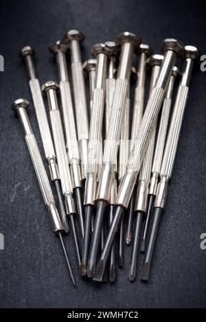 Nahaufnahme der Präzisionsschraubendreher-Gruppe auf schwarzer Oberfläche Stockfoto