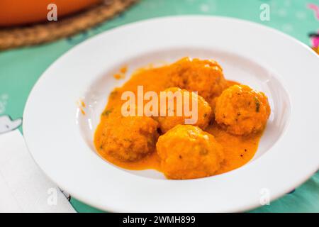 Ein Teller andalusischer Fleischbällchen mit Tintenfisch, serviert in einer herzhaften Tomatensauce. Stockfoto