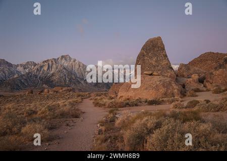 Shark Fin Rock, eine beliebte Sportkletterroute, in den Alabama Hills, während die Gipfel des Mt Whitney und der Eastern Sierra auf sich wirken. Stockfoto