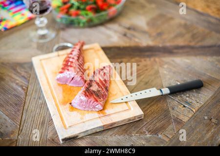 In Scheiben geschnittenes Tataki-Sirloin aus rotem Thunfisch auf einem Schneidebrett, fertig zum Servieren. Stockfoto