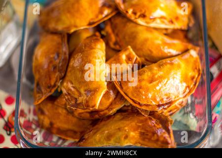 Goldbraune argentinische Empanadas, gestapelt in einer Glasschale. Stockfoto