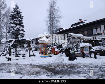 Schneebedeckte Bänke, Tische und Bäume in der Winterszene Stockfoto
