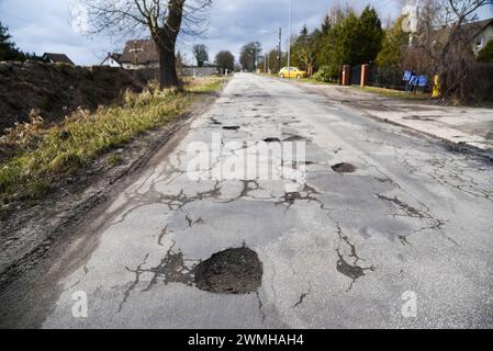 Loch in der Straße auf beschädigtem Asphaltgrund. Stockfoto