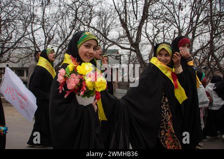 Budgam, Jammu Und Kaschmir, Indien. Februar 2024. Ein schiitisches Mädchen mit Blumen sieht zu, als er an der Kundgebung von Shaabaniya teilnimmt, die die Geburt von Imam al-Mahdi in Budgam markiert. Die Veranstaltung findet weltweit am 15. Sha'aban statt, dem achten Monat des islamischen Kalenders, um der Geburt des letzten schiitischen Imams, Muhammad al-Mahdi, zu gedenken. der glaubt, dass er nach Ansicht der schiitischen Muslime vor dem Ende der Zeit auftaucht, um der Welt Frieden und Gerechtigkeit zu bringen. Quelle: ZUMA Press, Inc./Alamy Live News Stockfoto