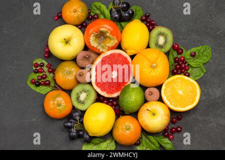 Verschiedene exotische Früchte in verschiedenen Farben. Mandarinen und Orangen, Kiwi und Birne, Persimmon und Litschi. Schwarzer Hintergrund. Flache Lagen Stockfoto