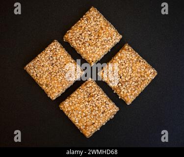 Bis Chikki auf schwarzgrauem Hintergrund. Till Chikki ist ein indisches Süßwarengericht, das mit Jaggery und Sesam zubereitet wird. Indisches Festival makar sankranti besonderes Süßes Stockfoto