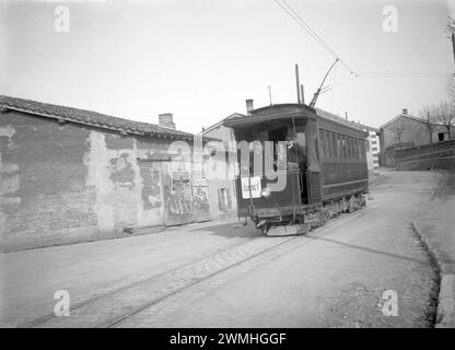 Leute laufen in einer gepflasterten Straße in Lyon. Neben einer Straßenbahn mit Publicities. Anfang des 20. Jahrhunderts. Altes Foto digitalisiert von Glasplatte Stockfoto