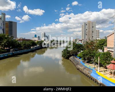 Fluss zwischen Wohngebiet in Metro Manila. Blauer Himmel und Wolken. Philippinen. Stockfoto