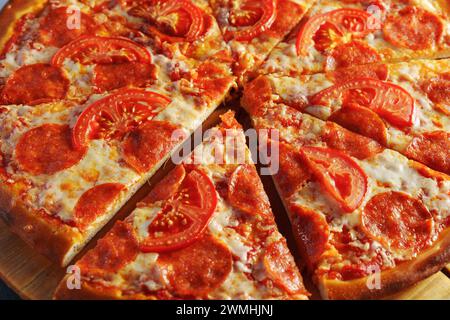 Köstliche Paprika- und Tomatenpizza auf Holzbrett Stockfoto