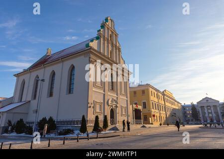 Minsk, Weißrussland - 7. Januar 2024: Blick auf die Straße mit Freiheitsplatz an einem sonnigen Wintertag gehen gewöhnliche Menschen die Straße vor der Oberstadt Co Stockfoto