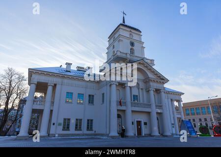 Minsk, Weißrussland - 7. Januar 2024: Außenansicht des Minsk Rathauses an einem Wintertag sind gewöhnliche Menschen auf der Straße Stockfoto