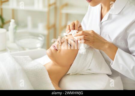 Kosmetikerin bei Anti-Age-Verfahren Reinigung mit Servietten Gesichtsmaske in der Schönheitsklinik. Stockfoto