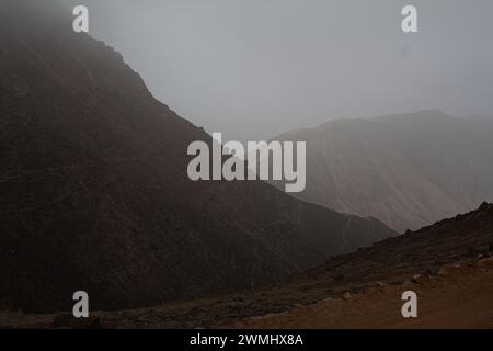 Horizontales Foto von oben auf braune Bergstraßen mit Felsen und Nebel auf der Spitze Stockfoto