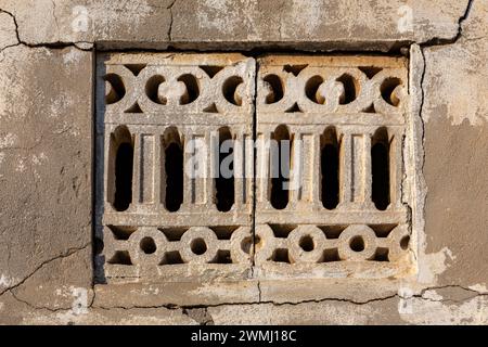 Altes Steinfenster im arabischen Stil mit gerissener Steinmauer rund um das verlassene Dorf Al Dschazirah Al Hamra in Ras Al Khaimah, Vereinigte Arabische Emirate. Stockfoto