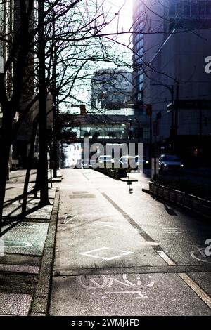 Ein Blick auf den Radweg auf der Dunsmuir Street, im wunderschönen Licht der Morgensonne, mit Autos, die in der Ferne außer Fokus stehen. Stockfoto