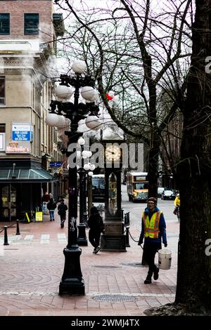 Ein Blick auf die Dampfuhr in Gastown, mit Dampf aus der Spitze. Das Foto zeigt auch die Farbe und Textur des gemauerten Gehwegs. Stockfoto