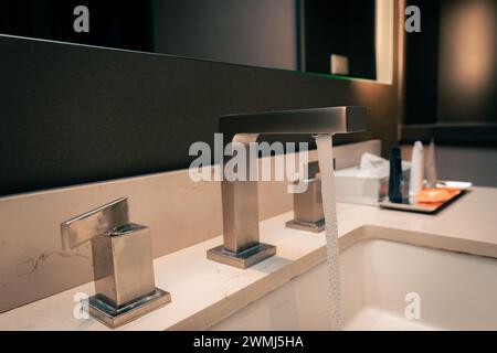 Hotelzimmer, Waschbecken im Bad und Metallarmatur Stockfoto