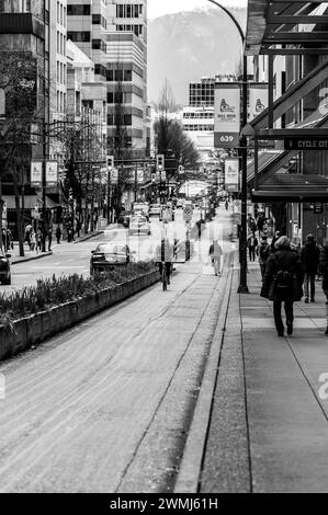 Vancouver, Kanada - 15. Februar 2024: Ein Schwarzweiß-Bild eines Radfahrers, der sich auf der Radspur die Hornby Street hinaufragt. Stockfoto