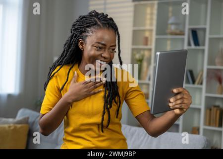 Glückliche junge afroamerikanische Frau mit Tablet zu Hause Stockfoto
