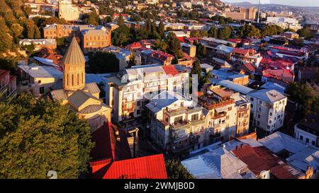 Fantastischer Blick auf die roten Dächer der Altstadt von Tiflis und die christlich-orthodoxe Kirche - beeindruckender Sommermorgen Stockfoto