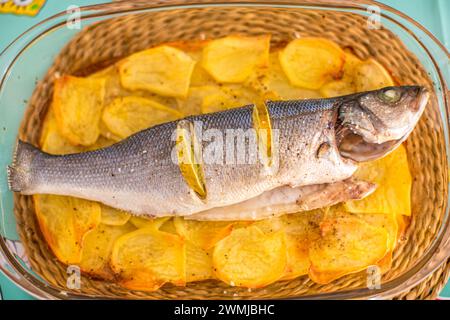 Saftiger Wolfsbarsch auf goldenen Kartoffeln, bereit für ein Festmahl. Stockfoto