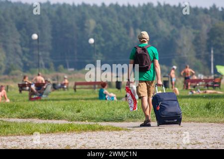 Rückkehr aus dem Urlaub, Ende des Urlaubs, ein Mann mit Koffer Stockfoto
