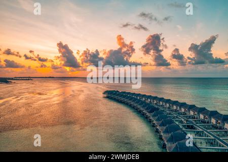 Luftaufnahme Sonnenuntergang Panoramablick Landschaft Luxus tropische Resort Wasservillen. Wunderschöner Inselstrand Sonnenaufgang Meereshimmel. Fantastisches Vogelaugenpanorama auf den Malediven Stockfoto
