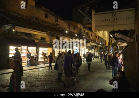 07-11-2013 Florenz, Italien - Fußgänger erkunden die Geschäfte entlang der Ponte Vecchio in Florenz und schaffen so ein magisches nächtliches Ambiente Stockfoto