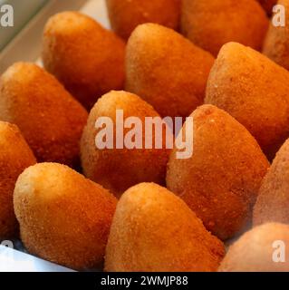 Viele frittierte Speisen, die in italienischer Sprache Aranini ora ARANCINE genannt werden, gefüllt mit Reis, Gemüse, Fleisch oder Käse, werden an einem Marktstand in Sizilien im Süden verkauft Stockfoto