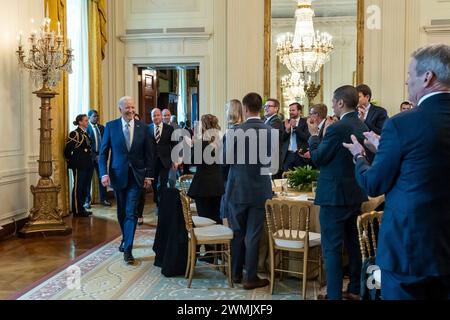 Washington, Vereinigte Staaten von Amerika. 23. Februar 2024. US-Präsident Joe Biden, links, lächelt, als er bei der Ankunft beim Winter Meeting Business Meeting der National Governors Association im East Room des Weißen Hauses am 23. Februar 2024 in Washington, D.C.Washington, USA, mit Applaus begrüßt wird. 23. Februar 2024. Stockfoto