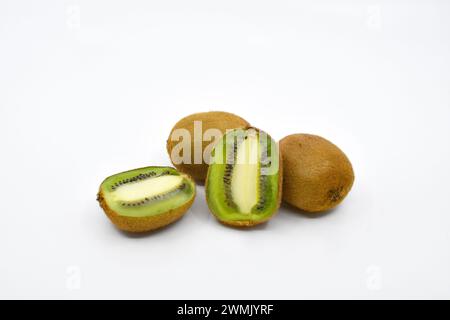 Kiwi-Frucht in zwei Hälften geschnitten mit zwei ganzen Kiwi-Früchten auf weißem Hintergrund. Kopierbereich. Stockfoto