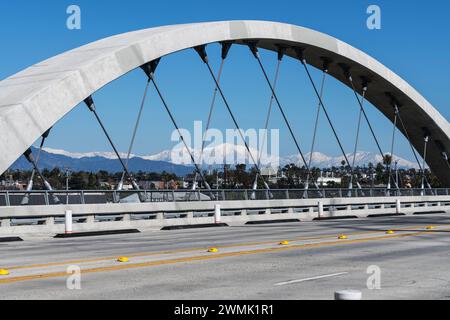 Los Angeles 6th Street Bridge Bogen mit schneebedecktem Mt Baldy und den San Gabriel Mountains im Hintergrund. Stockfoto