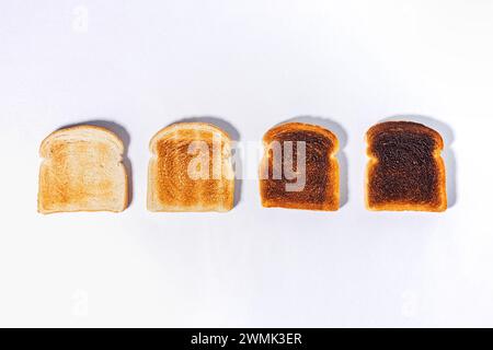 Verschiedene Toaststufen, geröstete quadratische Brotscheiben, Blick von oben Stockfoto