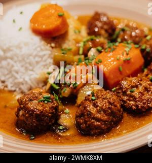 Teller mit Fleischbällchen mit Reis und Karotten in Sauce Stockfoto