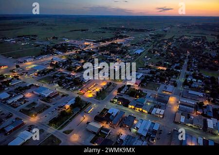 Blick aus der Vogelperspektive auf die Stadt Valentine, Nebraska nach Sonnenuntergang mit Lichtern auf Häuser, Unternehmen und leere Straßen Stockfoto