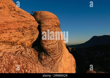 Kletterer hüpfen von Boulder zu Boulder auf versteinerten Dünen im Red Rock Canyon in Nevada nahe Las Vegas, einer der meistbesuchten des Bureau of Land Management... Stockfoto