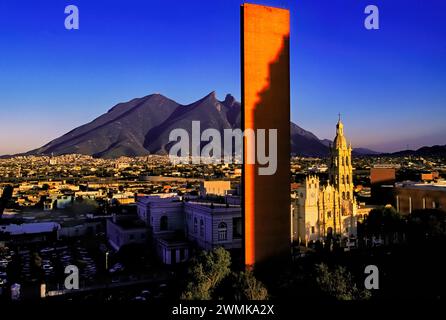 Blick auf die Hauptstadt Monterrey mit dem Naturdenkmal des Bergsattels Cerro de la Silla im Kontrast zum oran... Stockfoto