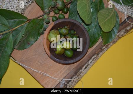 Araçá- oder Cattley-Guave-Frucht mit wissenschaftlichem Namen (Psidium Cattleianum) in rustikaler Holzschale Stockfoto