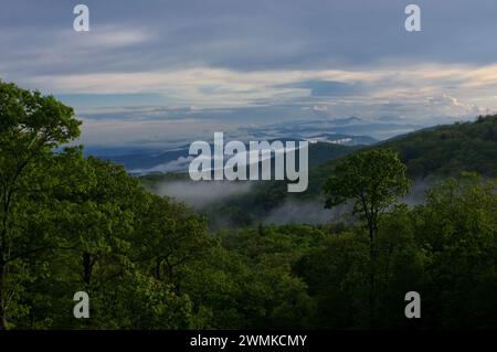 Nebel steigt aus dem Tal nach einem Regen, eine riesige Landschaft aus Bergen unter einem bewölkten Himmel Stockfoto