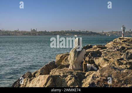 Frau genießt die Aussicht und wartet auf den Sonnenuntergang in Kadikoy, asiatische Seite, Istanbul, Türkei Stockfoto