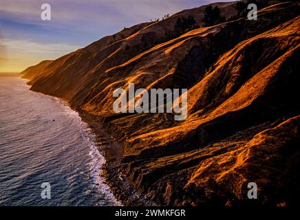 Aus der Vogelperspektive erleuchtet erodierte Hänge über den Wellen an der Küste der kalifornischen King Range National Conservation Area (NCA). Das Gebiet umfasst... Stockfoto