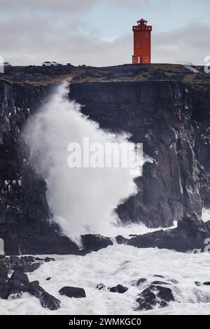 Surfen Sie auf den Klippen und dem roten Leuchtturm auf Skalasnagi, der Halbinsel Snaefellsnes, der Westküste Islands und Island Stockfoto