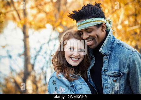 Nahaufnahme eines Paares mit gemischter Rasse, das sich auf einem Familienausflug im Herbst in einem Stadtpark in Edmonton, Alberta, Kanada, einlässt Stockfoto