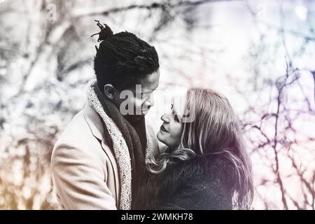 Nahaufnahme eines Paares mit gemischter Rasse, das sich gegenseitig in die Augen schaut, während es während eines Familienausflugs im Herbst in einem Stadtpark wertvolle Zeit miteinander verbringt Stockfoto