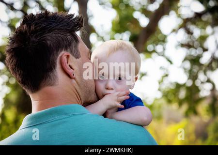 Außenporträt eines Vaters mit einem jungen Sohn, der an einem warmen Herbstnachmittag in einem Stadtpark an einem Down-Syndrom leidet; Leduc, Alberta, Kanada Stockfoto