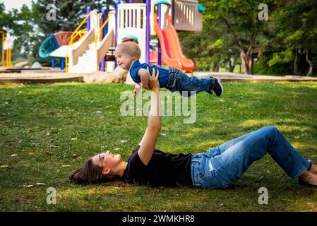 Schwester verbringt schöne Zeit im Freien mit ihrem kleinen Bruder, der das Down-Syndrom hat, in einem Stadtpark an einem warmen Herbstnachmittag Stockfoto